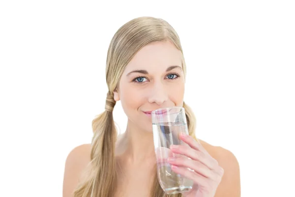 Улыбающаяся молодая блондинка пьет воду — стоковое фото