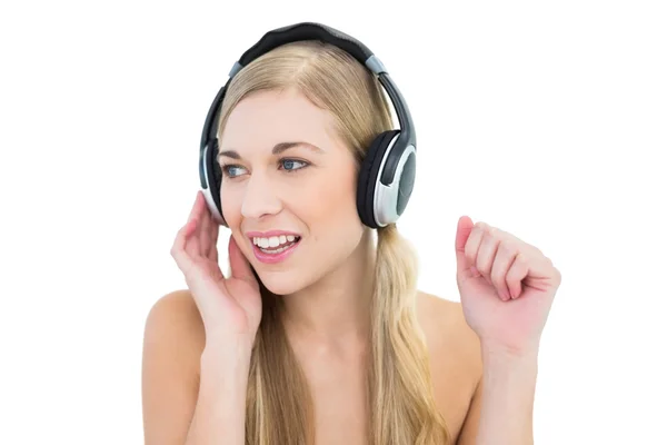 Ernstige jonge blonde vrouw luisteren naar muziek — Stockfoto