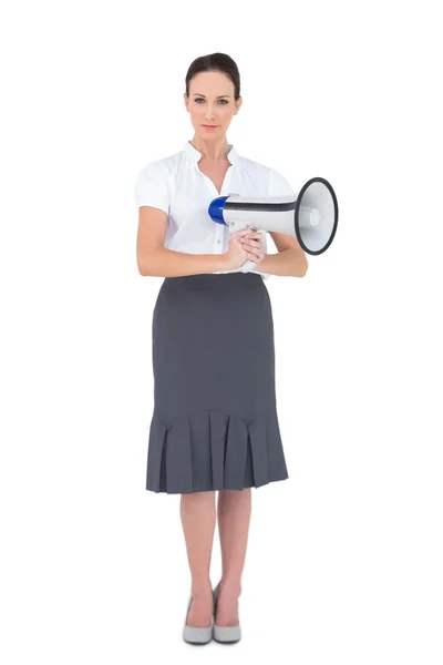 Unsmiling businesswoman holding megaphone — Stock Photo, Image