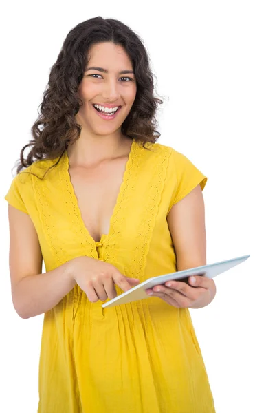 笑顔のカジュアルな若い女性彼女のタブレット コンピューター上のスクロール — ストック写真