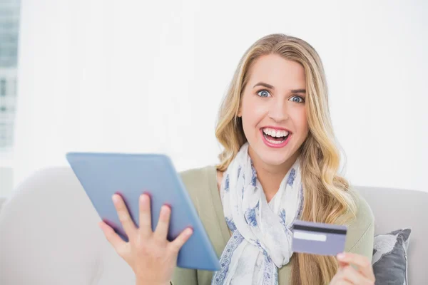 Lächelnde hübsche Blondine mit ihrer Kreditkarte online kaufen — Stockfoto