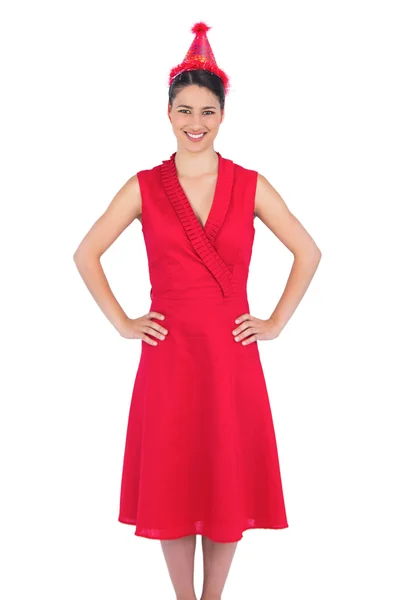 Glimlachend prachtige brunette in rode jurk dragen feest hoed — Stockfoto
