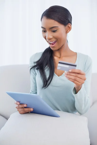 Surprised attractive woman using her tablet pc to buy online — Stock Photo, Image