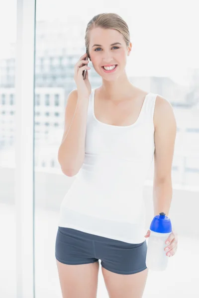 Alegre deportista mujer teniendo una llamada telefónica — Foto de Stock