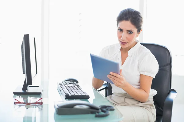 Mujer de negocios Stern utilizando su tableta digital en el escritorio —  Fotos de Stock