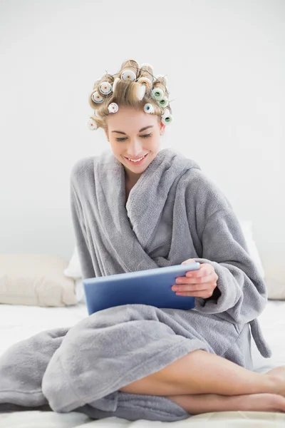 Ganska avslappnad blonda kvinnan i Hårrullar använder en TabletPC — Stockfoto