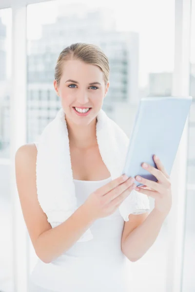 Fröhliche sportliche Frau hält Tablet-PC in der Hand — Stockfoto