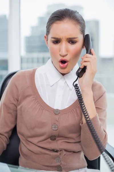 Angry businesswoman picking up the phone — Stock Photo, Image