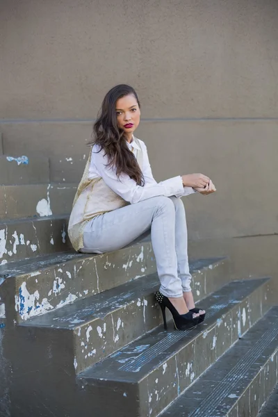Hezká brunetka sedí na schodech — Stock fotografie