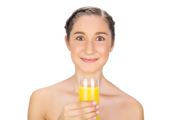 Modelo lindo ganancioso segurando vidro de suco de laranja — Fotografia de Stock