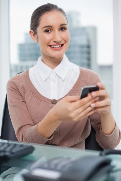 Cheerful beautiful businesswoman text messaging — Stock Photo, Image
