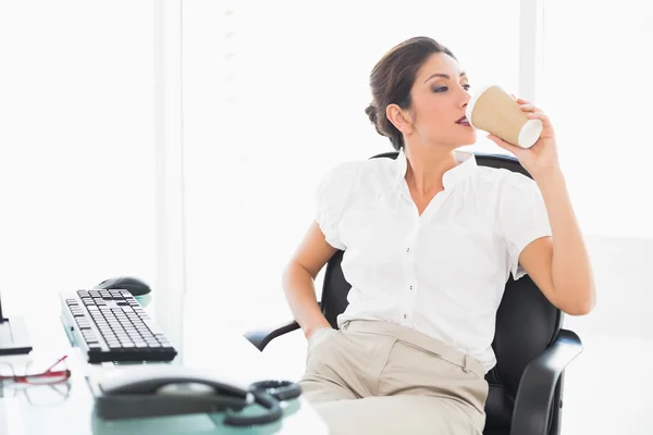 Ontspannen zakenvrouw drinken een kopje koffie op haar Bureau — Stockfoto