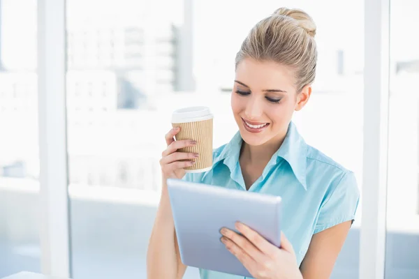 Veselá žena pomocí tabletu drží kávy — Stock fotografie