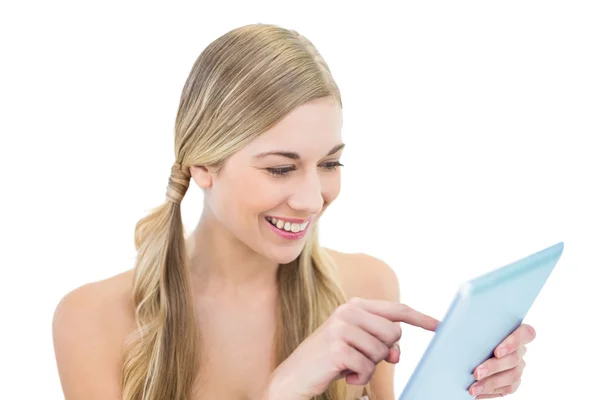 Amüsierte junge blonde Frau mit einem Tablet-PC — Stockfoto