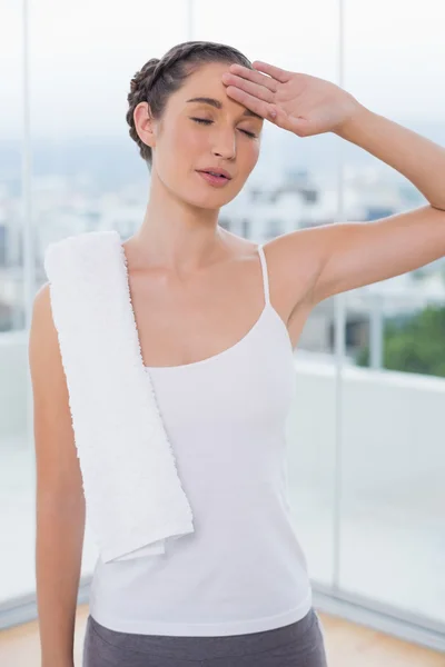 Sporty brunette wiping her forehead after exercising — Stock Photo, Image