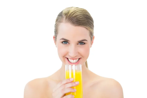 Lachende aantrekkelijke blonde houden glas sinaasappelsap — Stockfoto
