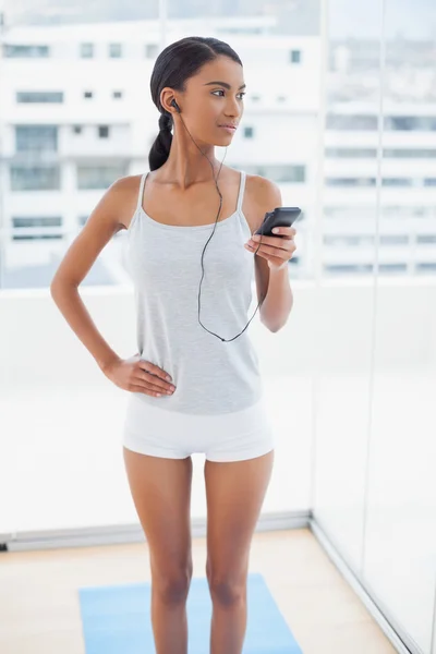 Doordachte prachtige model in sportkleding luisteren naar muziek — Stockfoto