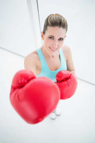 Smiling fit woman wearing red boxing gloves — Stock Photo, Image