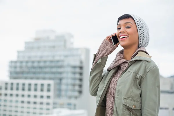 Smějící se mladý model v zimní oblečení odpovídá její telefon — Stock fotografie