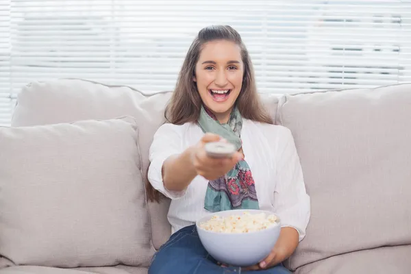 Happy cute model changing tv channel — Stock Photo, Image