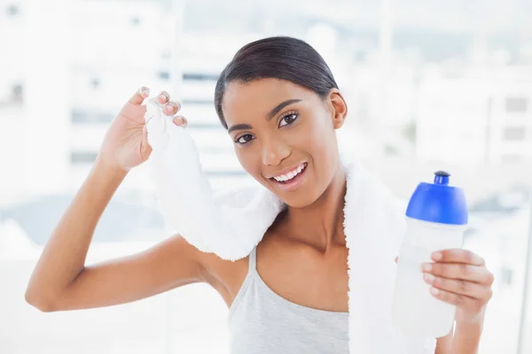 Sorrindo modelo desportivo segurando frasco e toalha de esporte — Fotografia de Stock