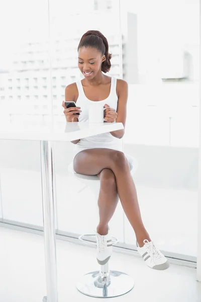 Lachende atletische vrouw kijken naar haar smartphone — Stockfoto