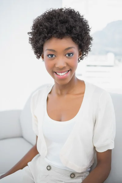 Smiling pretty brunette sitting on cosy sofa — Stock Photo, Image