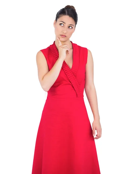 Promyšlené elegantní brunetka v červených šatech pózuje — Stock fotografie