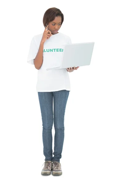 Mujer voluntaria reflexiva mirando su computadora portátil —  Fotos de Stock