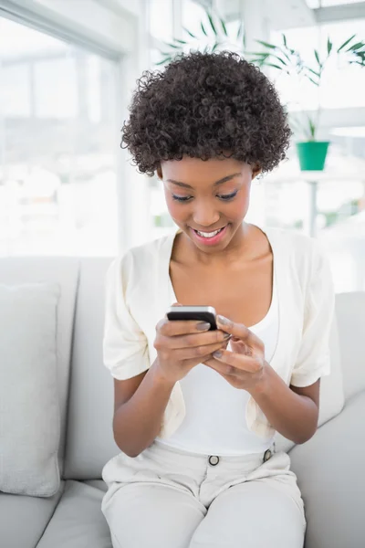 Avslappnad vackra brunett håller sin smartphone — Stockfoto