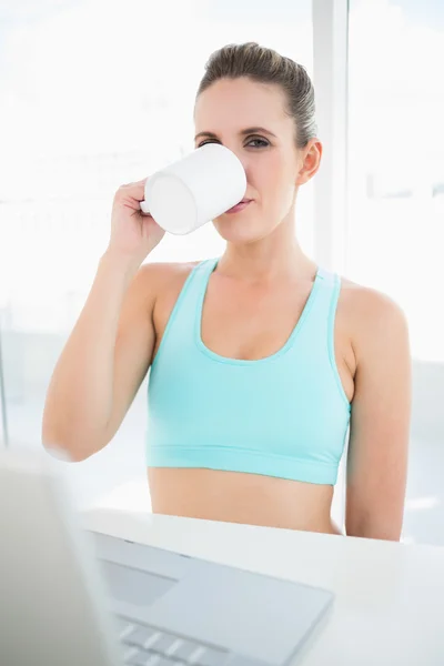 Woman wearing sportswear drinking coffee — Stock Photo, Image