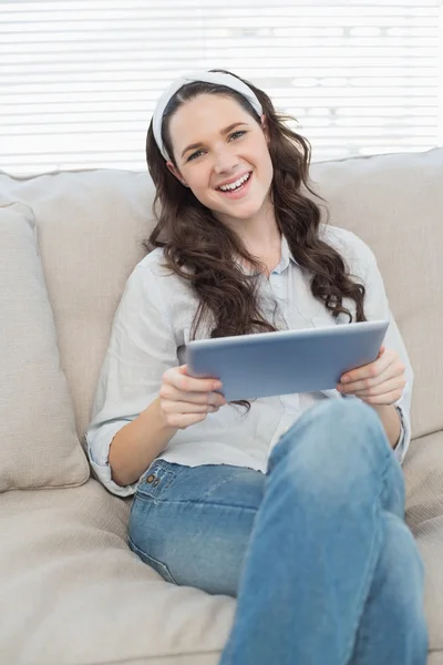 Mujer casual feliz en el sofá acogedor usando la tableta PC —  Fotos de Stock