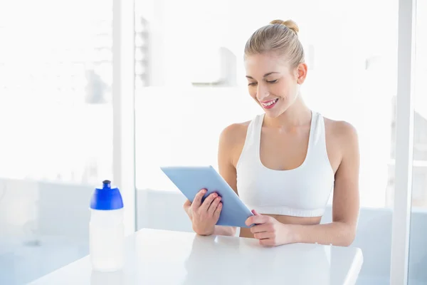 Attractive young blonde model using a tablet pc — Stok fotoğraf