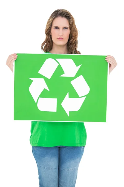 Unsmiling environmental activist holding recycling sign — Stock Photo, Image