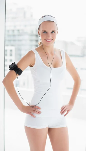 Amused pretty sportswoman listening to music — Stock Photo, Image