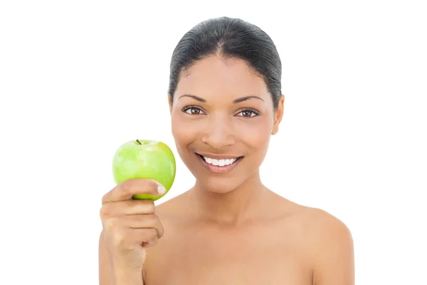 Cheerful black haired model holding green apple — Stock Photo, Image