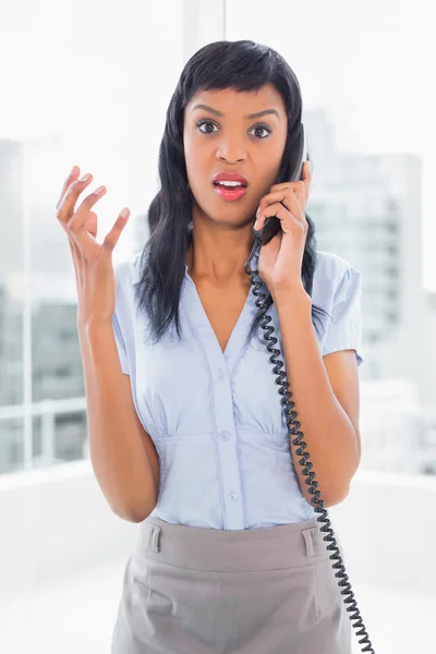 Angry businesswoman answering the phone — Stock Photo, Image