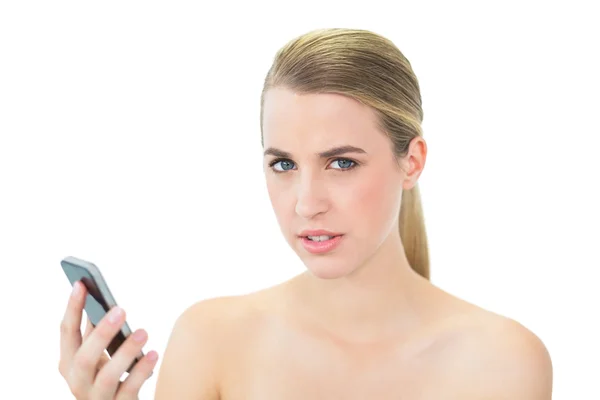 Ernsthafte attraktive Blondine hält ihr Smartphone — Stockfoto