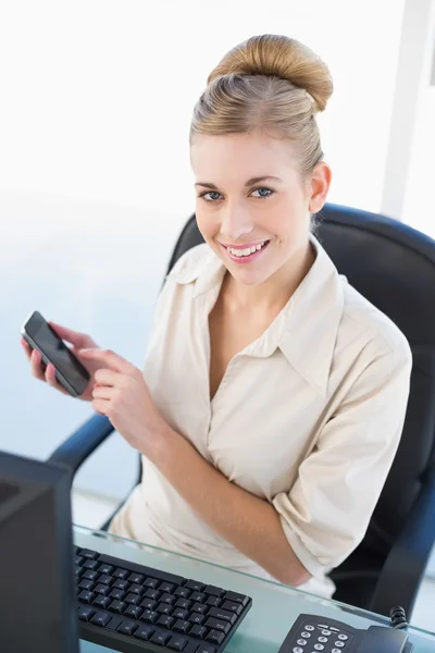 Happy young blonde businesswoman using her mobile phone — Stock Photo, Image