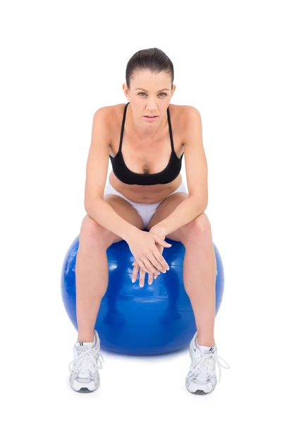 Mujer seria en forma sentada en la pelota de ejercicio —  Fotos de Stock