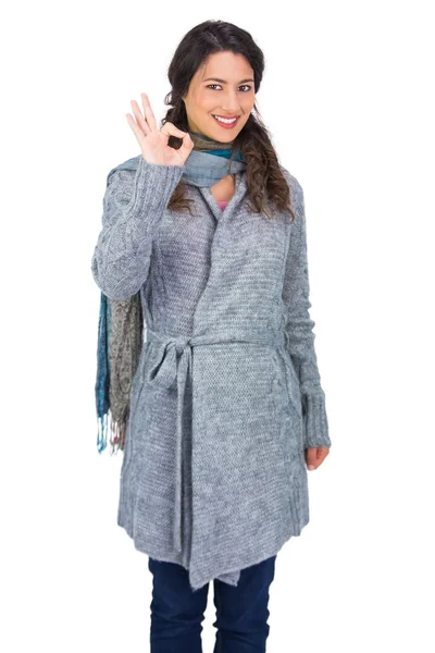 Sorrindo morena bonita vestindo roupas de inverno fazendo ok gesto — Fotografia de Stock