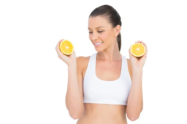 Fit woman holding slices of orange — Stock Photo, Image