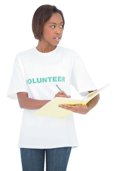 Pretty volunteer woman writing on notebook — Stock Photo, Image