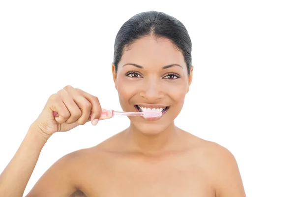 Cheerful black haired model brushing her teeth — Stock Photo, Image