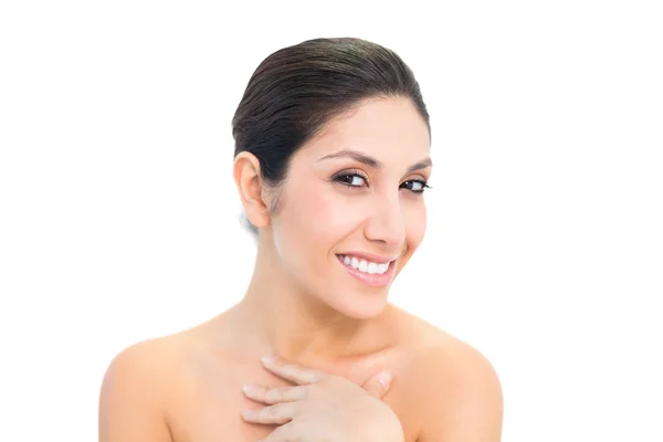 Smiling brunette looking at camera with hand on chest — Stock Photo, Image