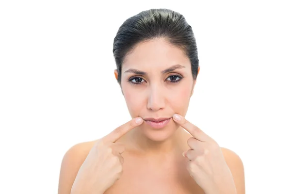 Brunette pointing to mouth and looking at camera — Stock Photo, Image