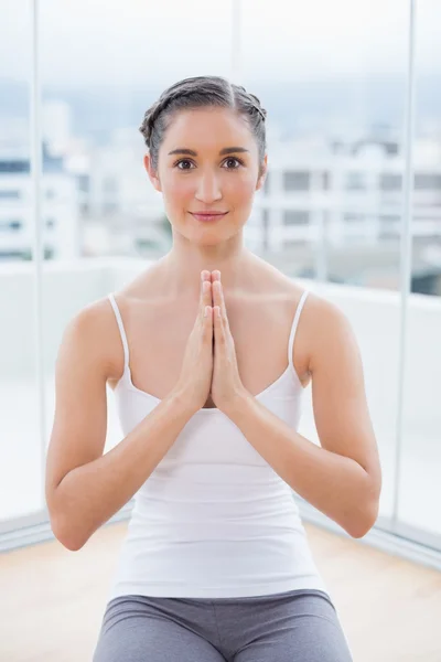 Lächelnde sportliche Brünette sitzt in Yoga-Haltung — Stockfoto