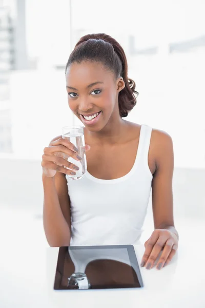 Šťastné sportovní model drží sklenici vody — Stock fotografie