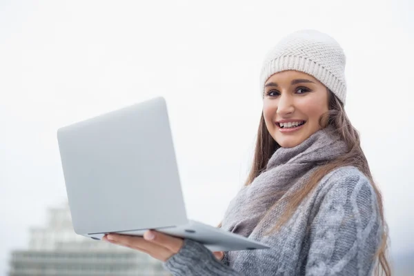 Souriant magnifique femme avec des vêtements d'hiver sur l'utilisation de son ordinateur portable — Photo