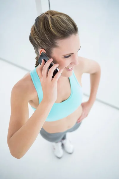 Vrouw in sportkleding praten op mobiele telefoon past — Stockfoto